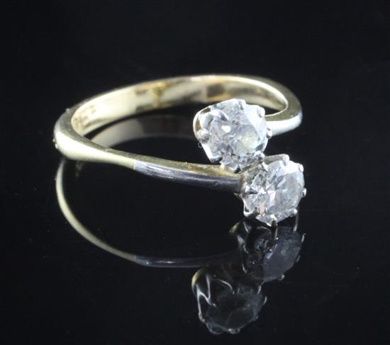 An 18ct gold and two stone diamond crossover ring, size L.